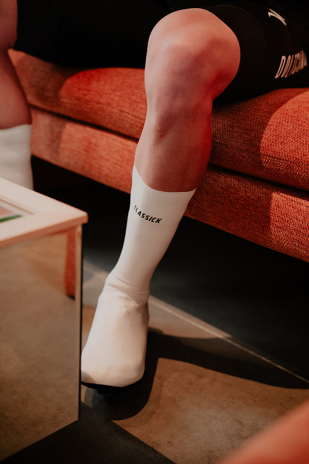 Witte Flandrien Shoe Covers gedragen bij een caféstoel.