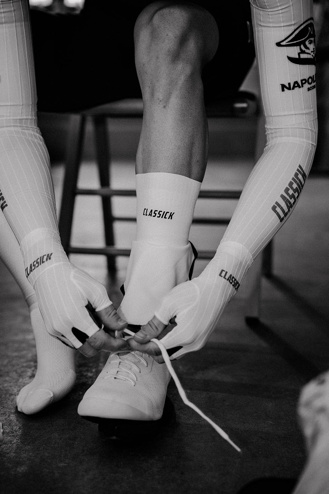Een renner strikt witte fietsschoenen met Classick sokken en handschoenen.